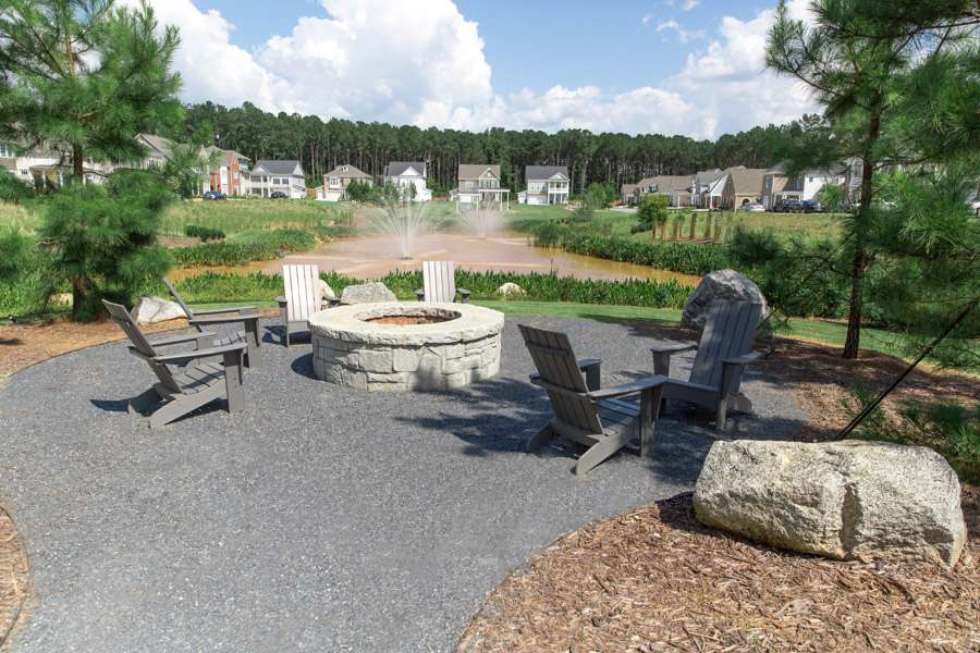 Outdoor fire pit with chairs by pond in suburban neighborhood in Metro Atlanta