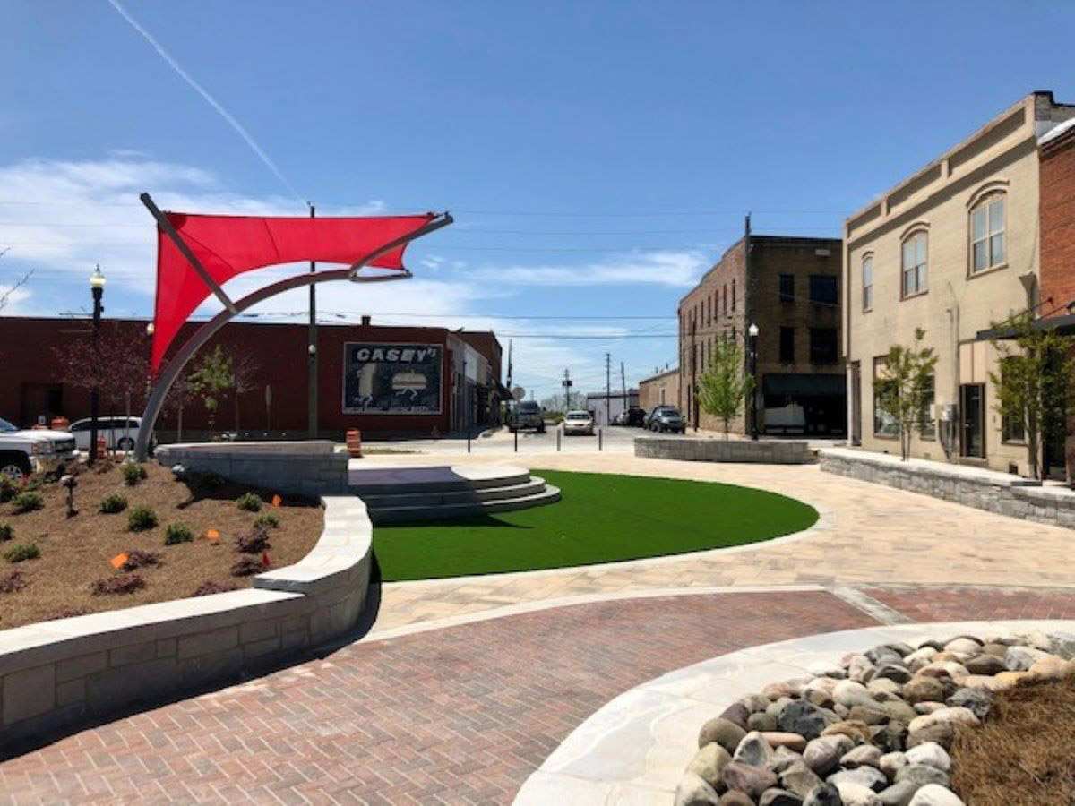 Small urban plaza with red shade structure and circular lawn in Metro Atlanta
